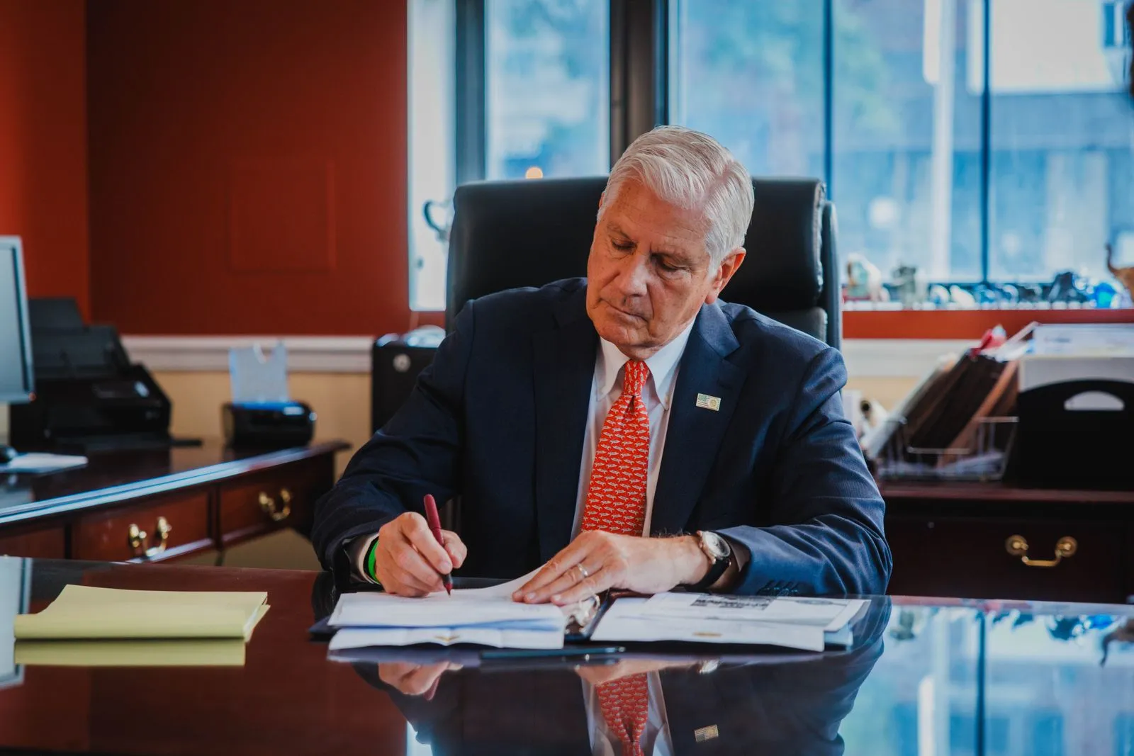 Bruce Blakeman writing at his desk.